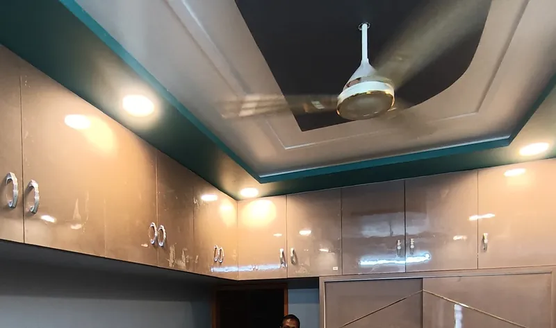 Layered false ceiling with a teal edge, downlights and loft cabinets