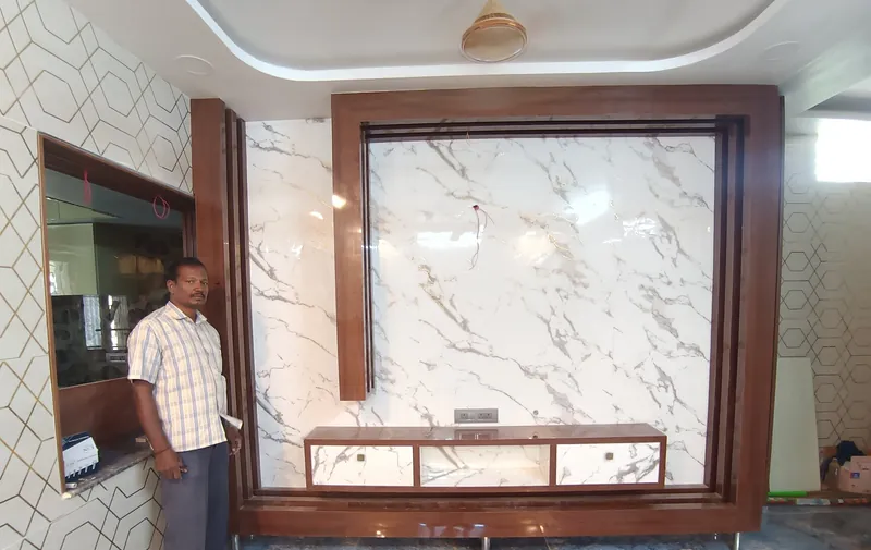 TV wall with a white marble-pattern panel in a wood frame